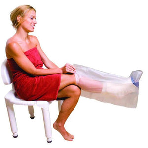 Woman in a red dress sitting on a white chair with a clear plastic bag over her legs. - okotoks hc pharmacy