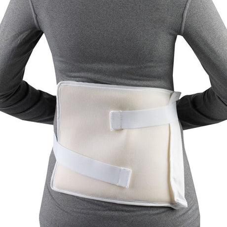 A back support brace with white straps and a beige foam insert, shown worn on a person's lower back against a white background. - okotoks hc pharmacy