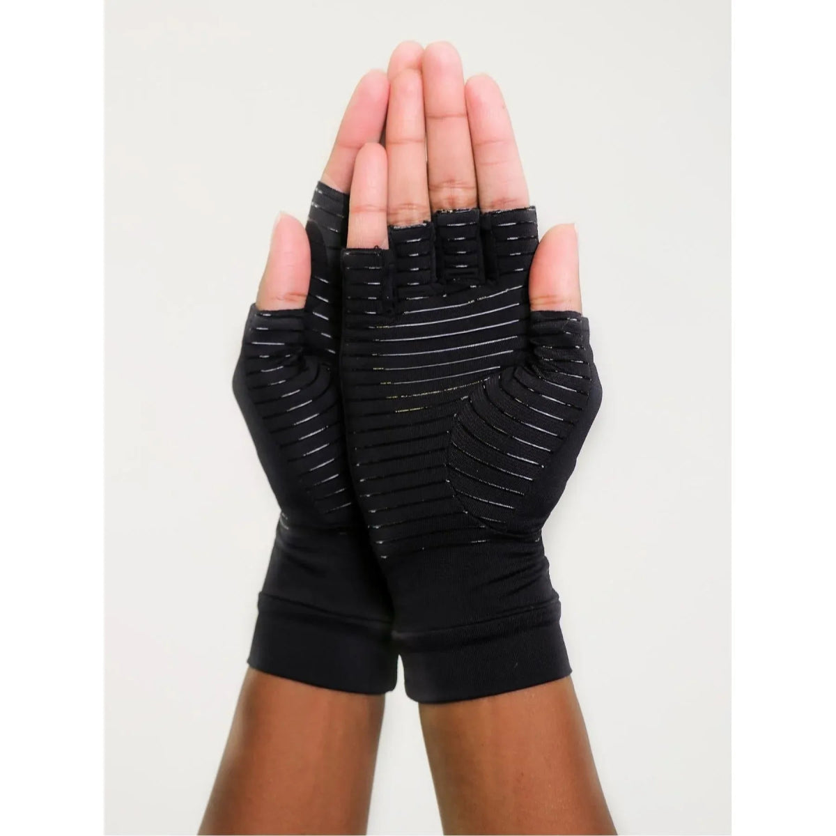 Black fingerless gloves with textured palm held up against a light background - okotoks hc pharmacy
