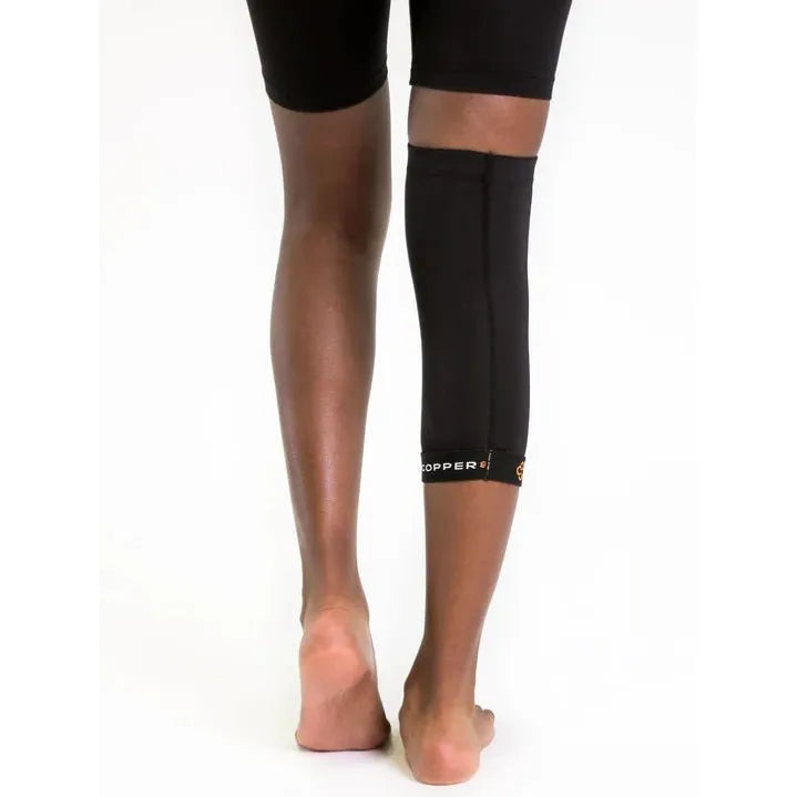 Person wearing black compression sleeves on legs with a white background - okotoks hc pharmacy