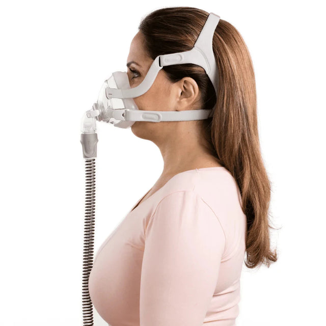 Woman wearing a white CPAP mask with hose on a white background - okotoks hc pharmacy