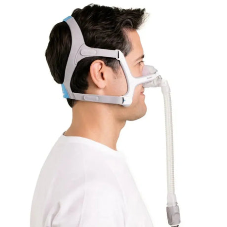 Person wearing a CPAP mask with a white background - okotoks hc pharmacy