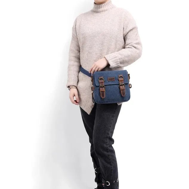 Person wearing a beige sweater and dark jeans with a blue bag featuring brown leather straps on a white background - okotoks hc pharmacy