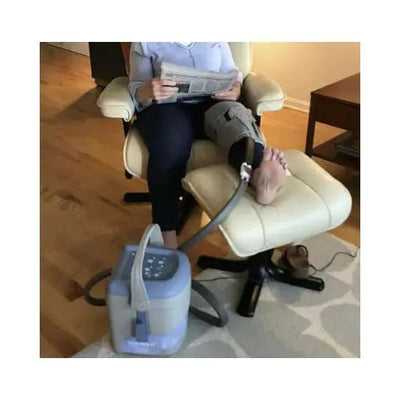 Person using a leg elevation device with a machine on the floor. - okotoks hc pharmacy