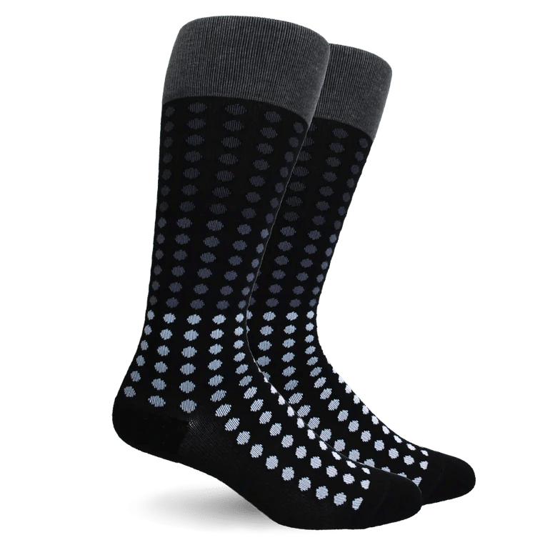 A pair of black crew socks with a gray ribbed cuff and a pattern of small light blue and white dots that fade into black toward the toes, shown on a white background. - okotoks hc pharmacy