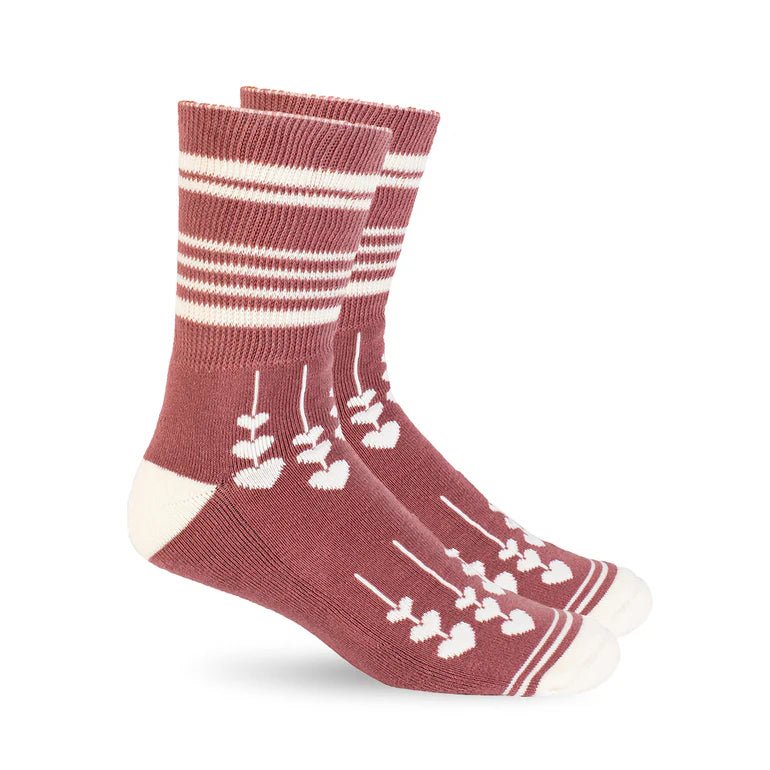 A pair of crew socks in a dusty rose color with white stripes near the cuff, white arrow motifs, and white toe and heel sections, shown on a plain white background. - okotoks hc pharmacy