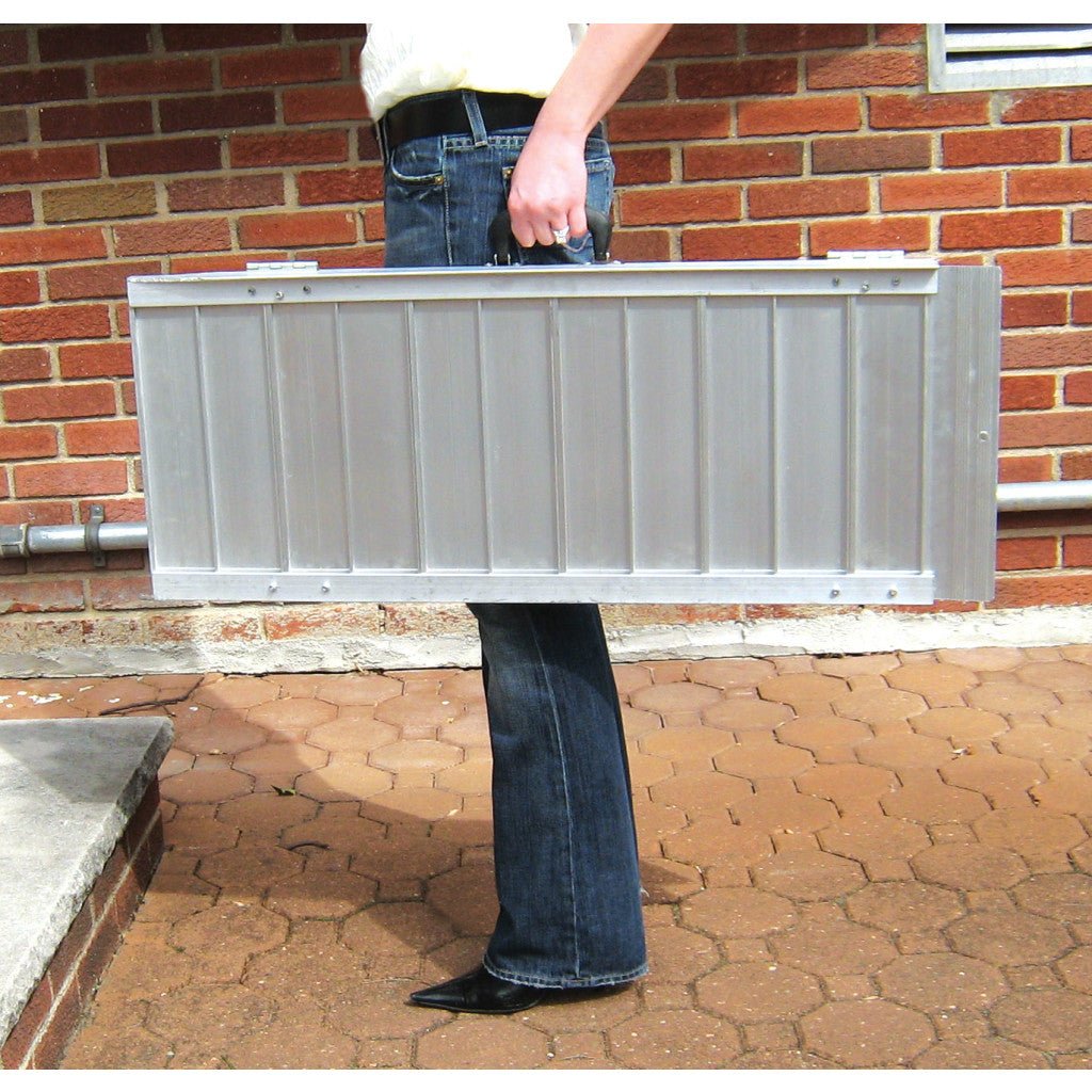 Person holding a metal ramp against a brick wall - okotoks hc pharmacy