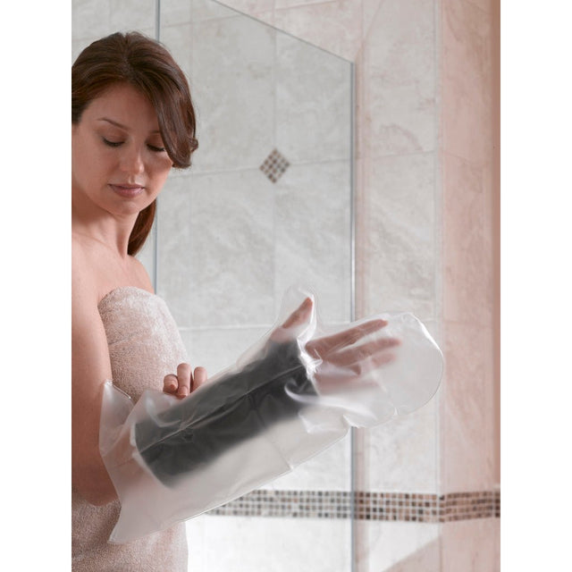 Woman applying a black foot mask in front of a mirror. - okotoks hc pharmacy