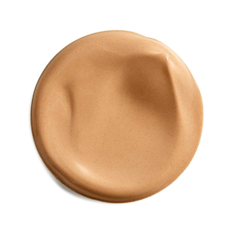 A circular smear of light tan liquid foundation or cream makeup on a plain white background. - okotoks hc pharmacy