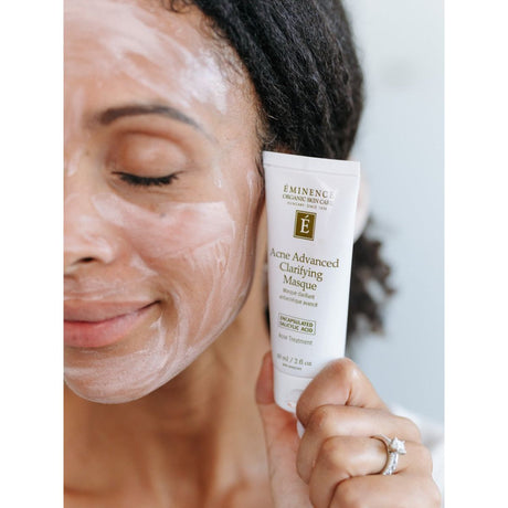 Woman applying Eminence Acne Advanced Clarifying Masque to her face. - okotoks hc pharmacy