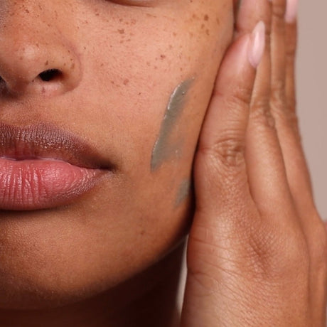 Close-up of a person applying skincare product to their face. - okotoks hc pharmacy