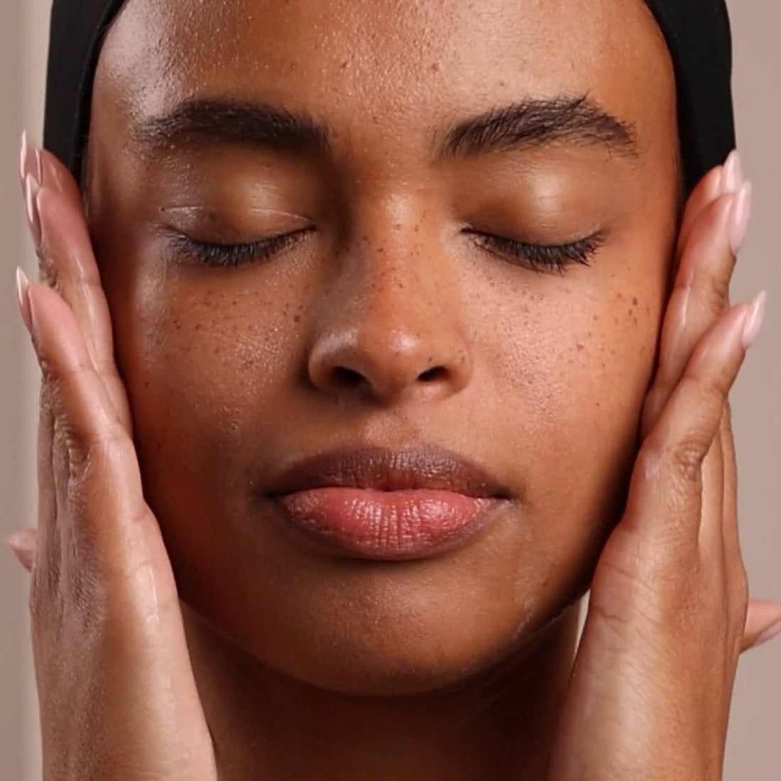 Close-up of a person with hands on either side of their face against a neutral background - okotoks hc pharmacy