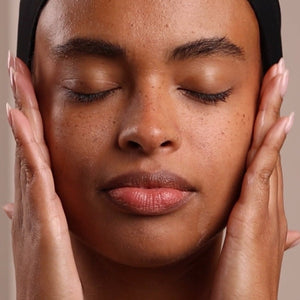 Close-up of a person with hands on either side of their face against a neutral background - okotoks hc pharmacy