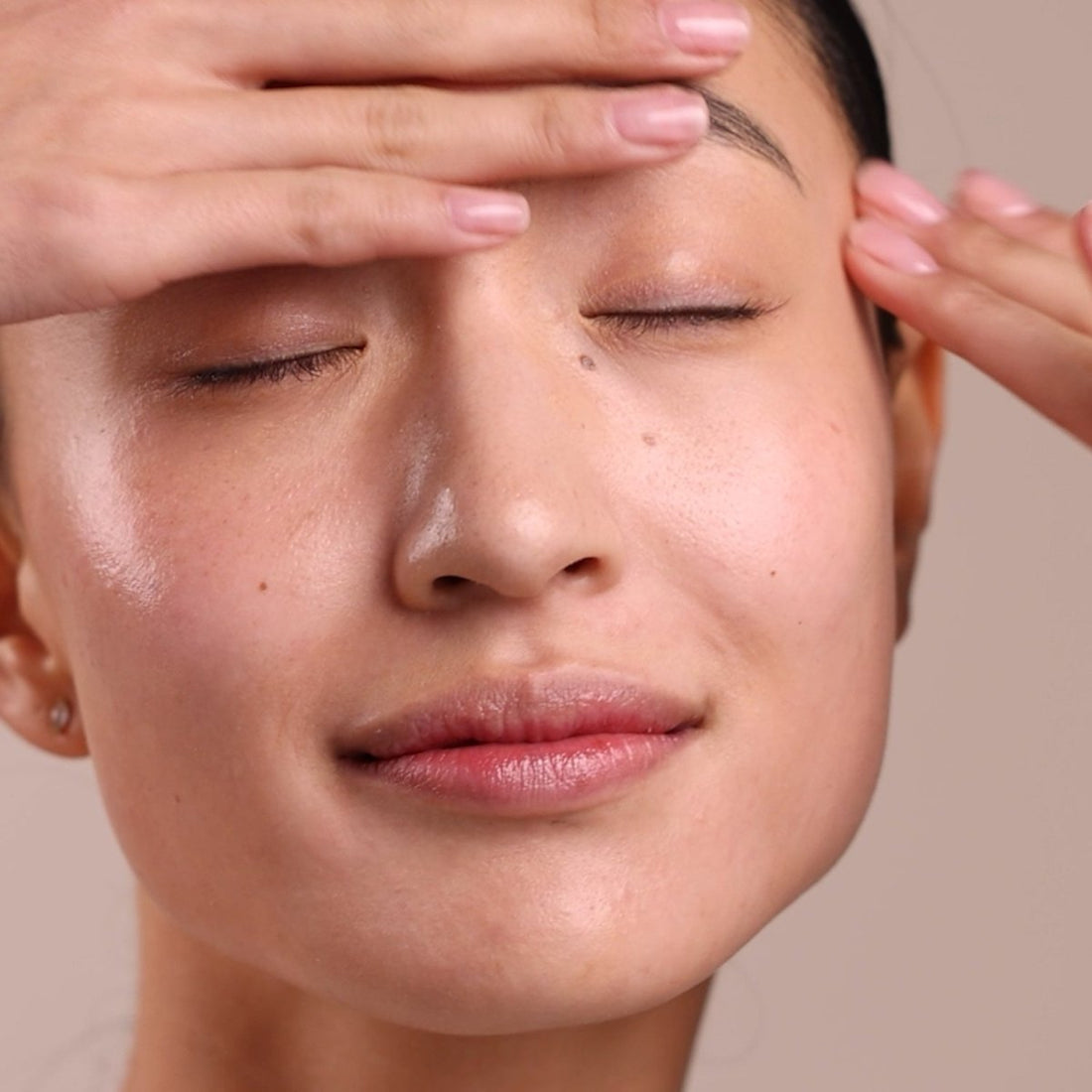 Close-up of a person with hands on their face against a beige background - okotoks hc pharmacy