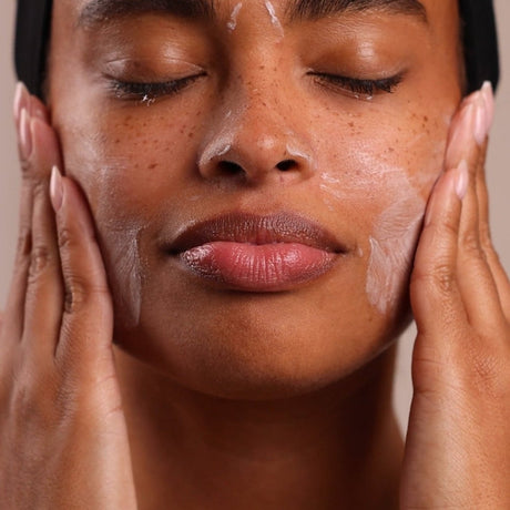 Close-up of a person applying a skincare product to their face. - okotoks ha pharmacy
