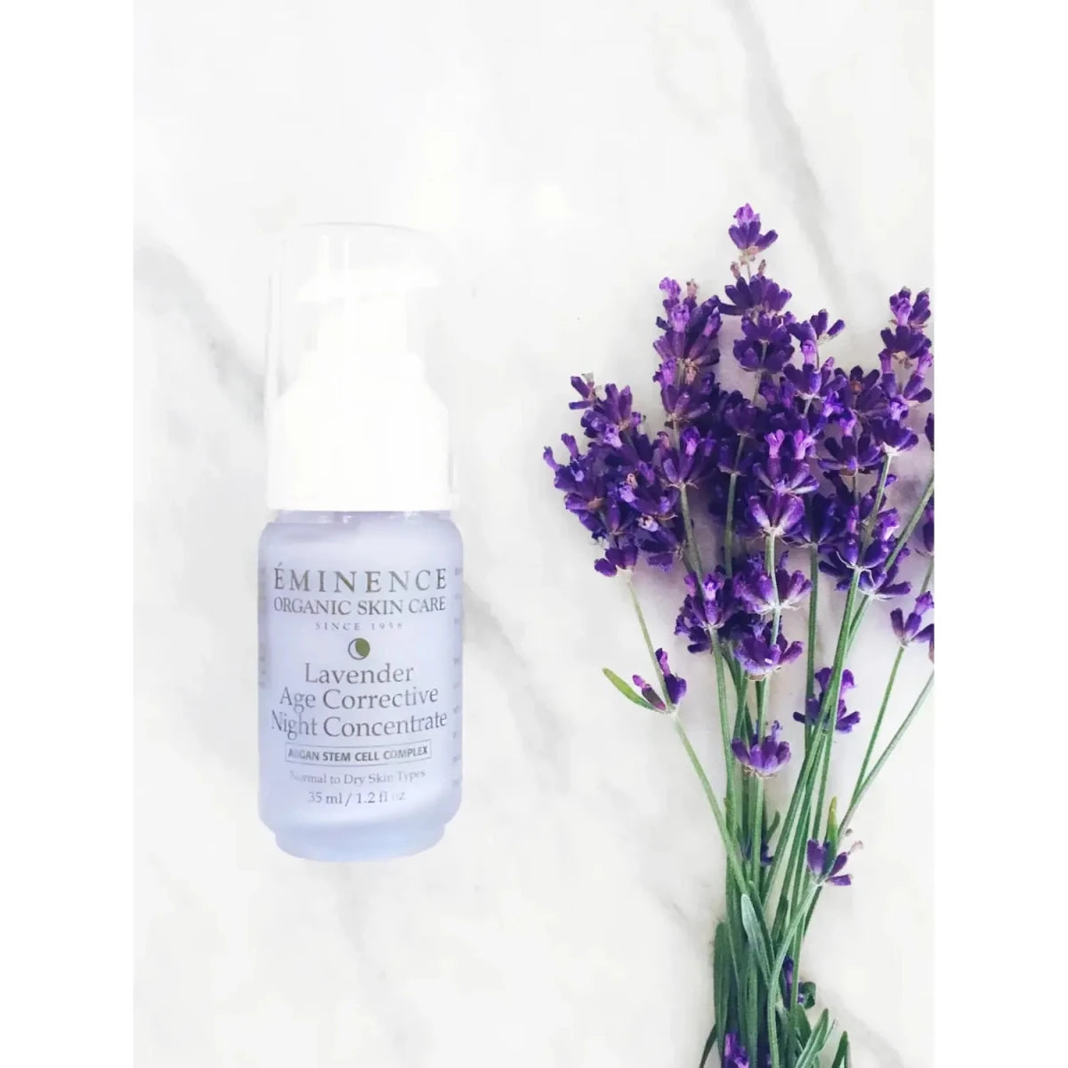 Eminence Lavender Age Corrective Night Concentrate bottle with lavender flowers on a white background