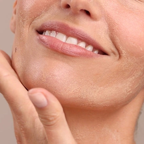 Close-up of a person's face with a hand gently touching the cheek, against a neutral background. - okotoks hc pharmacy