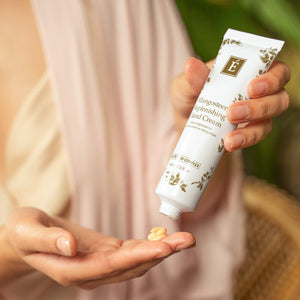 Hand holding a tube of hand cream with visible brand logo, against a blurred natural background. - okotoks hc pharmacy