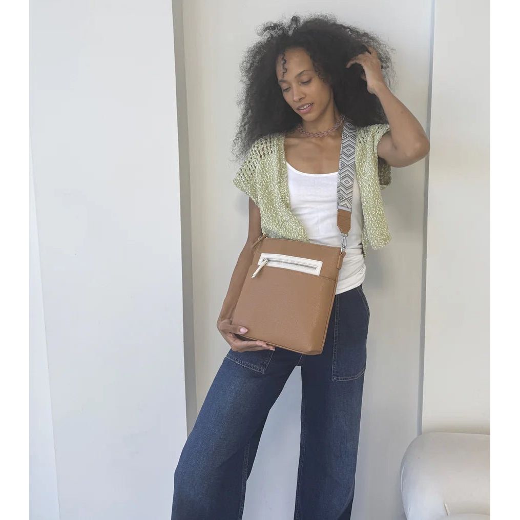 Woman holding a brown clutch against a white background - okotoks hc pharmacy