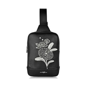Black sling bag with white floral design on a white background - okotoks hc pharmacy
