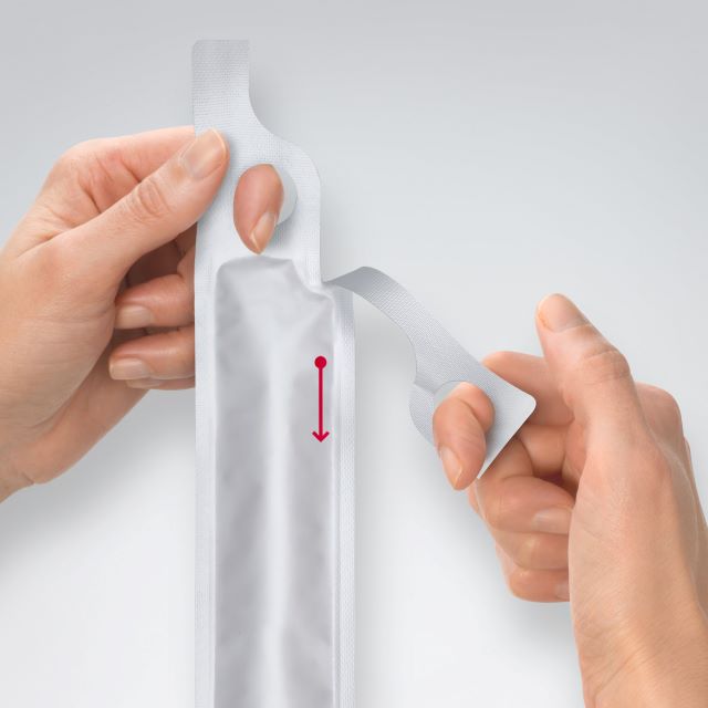 Hands holding a clear plastic strip with a red arrow on a white background - okotoks hc pharmacy