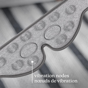 Close-up of a gray textured wearable device with oval and circular vibration nodes, overlaid with the text 'vibration nodes / nœuds de vibration' on a blurred striped background. - okotoks hc pharmacy