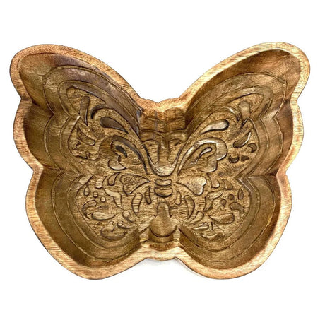 Wooden butterfly-shaped object with intricate carvings on a white background - okotoks hc pharmacy