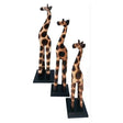 Three giraffe figurines on stands against a white background - okotoks hc pharmacy