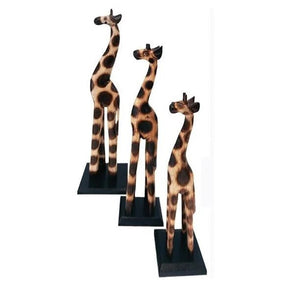 Three giraffe figurines on stands against a white background - okotoks hc pharmacy