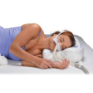 Woman using a CPAP machine with a pillow and mask on a white background - okotoks hc pharmacy