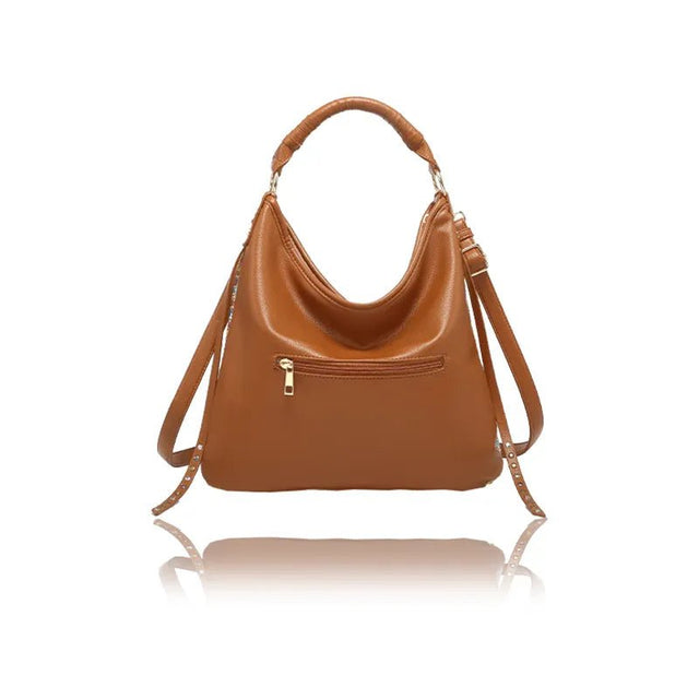 Brown leather handbag with a reflective surface on a white background - okotoks hc pharmacy