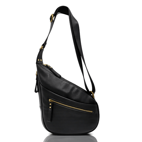 A black leather shoulder bag with gold-tone hardware and a long strap, shown from a side profile on a reflective white surface. - okotoks hc pharmacy