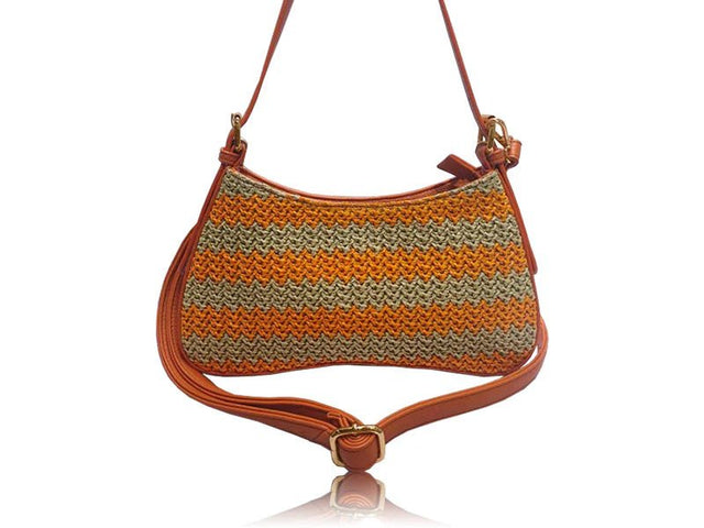 A small shoulder bag with a brown leather strap and trim, featuring a textured woven body with horizontal stripes of orange, beige, and brown, shown on a white background with a reflection. - okotoks hc pharmacy