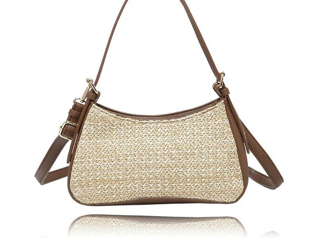 A woven straw shoulder bag with brown leather trim and straps, shown against a plain white background with a subtle reflection. - okotoks hc pharmacy