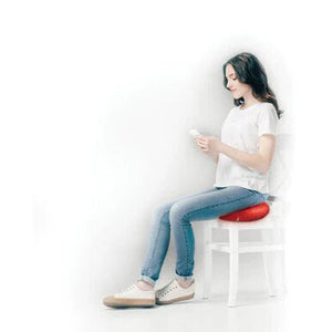 Woman sitting on a white chair with a red cushion, using a smartphone. - okotoks hc pharmacy