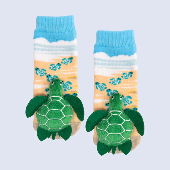 Pair of socks with turtle design on a beach scene background - okotoks hc pharmacy