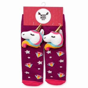 A pair of children's socks in magenta-purple with plush unicorn heads, colorful diamond motifs, and white stars, attached to a pink retail hanger card labeled 'Messy Moose Socks'. - okotoks hc pharmacy