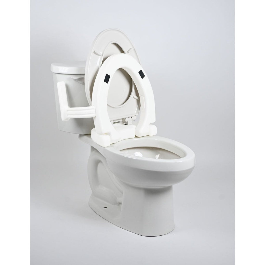 White toilet with an open seat on a light gray background - okotoks hc pharmacy
