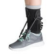 Ankle support brace on a foot wearing a gray athletic shoe with green accents. - okotoks hc pharmacy