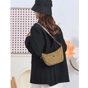 Person wearing a black coat and hat with a beige bag on a white background - okotoks hc pharmacy