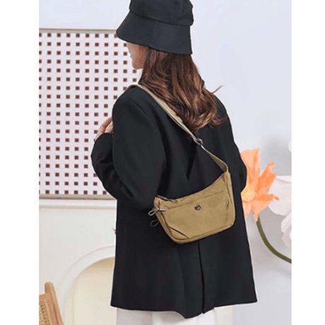 Person wearing a black coat and hat with a beige bag on a white background - okotoks hc pharmacy