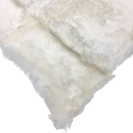 A close-up of a soft, fluffy faux fur or sheepskin material in an off-white color, shown folded against a plain white background. - okotoks hc pharmacy