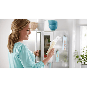 Woman holding a baby bottle in a kitchen setting - okotoks hc pharmacy
