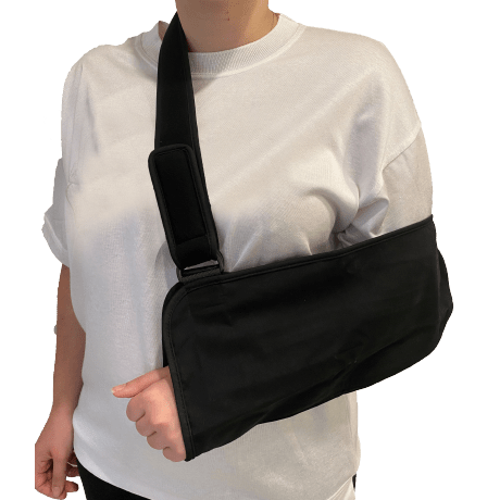 Person wearing a black shoulder immobilizer against a white background - okotoks hc pharmacy
