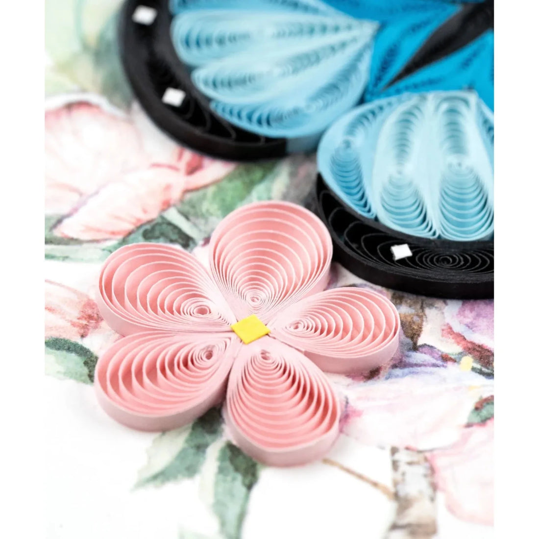 Pink paper flower with a yellow center on a floral background - okotoks hc pharmacy