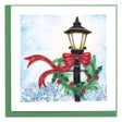 Decorative card with a Christmas-themed street lamp, red ribbon, and greenery against a snowy background. - okotoks hc pharmacy