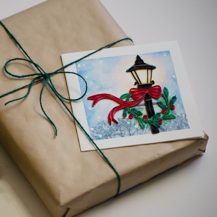 Gift wrapped in brown paper with a decorative card featuring a lamp post and red ribbon. - okotoks hc pharmacy