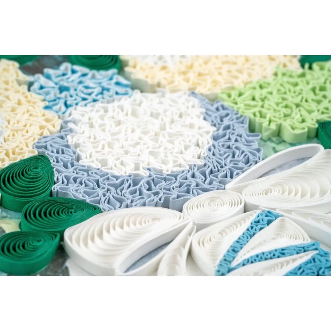 Colorful paper quilling patterns in green, blue, and white on a textured surface. - okotoks hc pharmacy