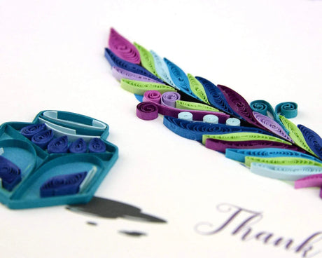 Colorful paper quilling strips with a pair of scissors on a white background - okotoks hc pharmacy