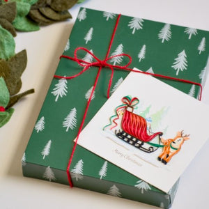 Gift box with Christmas tree pattern and Santa Claus design on a white background - okotoks hc pharmacy
